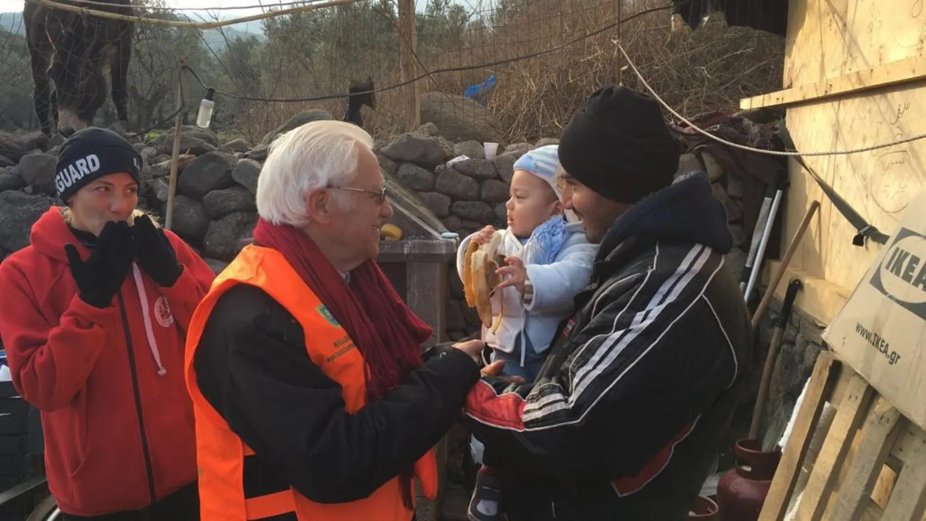 Entrañable imagen, el Padre Ángel, en el centro, ofreciendo alimento a un bebé turco en brazos de su padre, a la izda., la madre del niño.