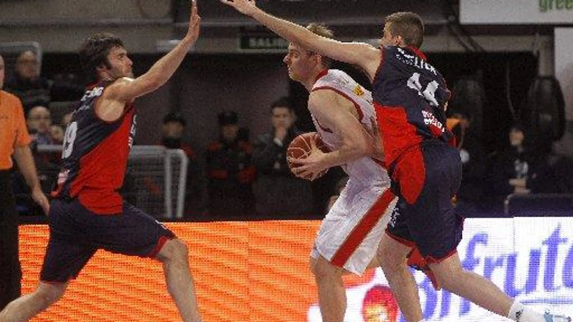 El pívot holandés del CAI Zaragoza, Henk Norel (c), avanza ante la defensa del alero Fernando San Emeterio (i) y el alero serbio Nemanja Bjelica (d), del Caja Laboral Baskonia