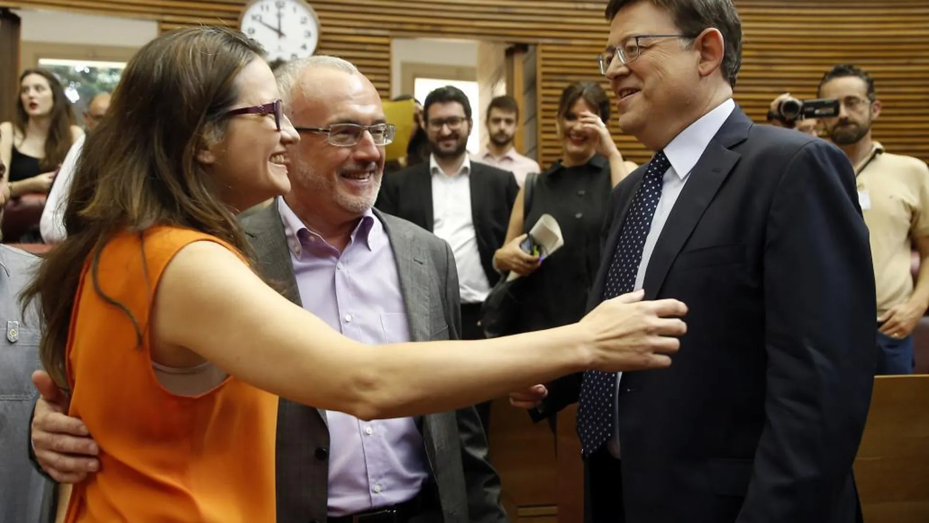 El candidato a la presidencia de la Generalitat, Ximo Puig (d), saluda a los candidatos de Compromis, Monica Oltra (i), y Podemos, Antonio Montiel, a su llegada al pleno de Les Corts Valencianes para su investidura.