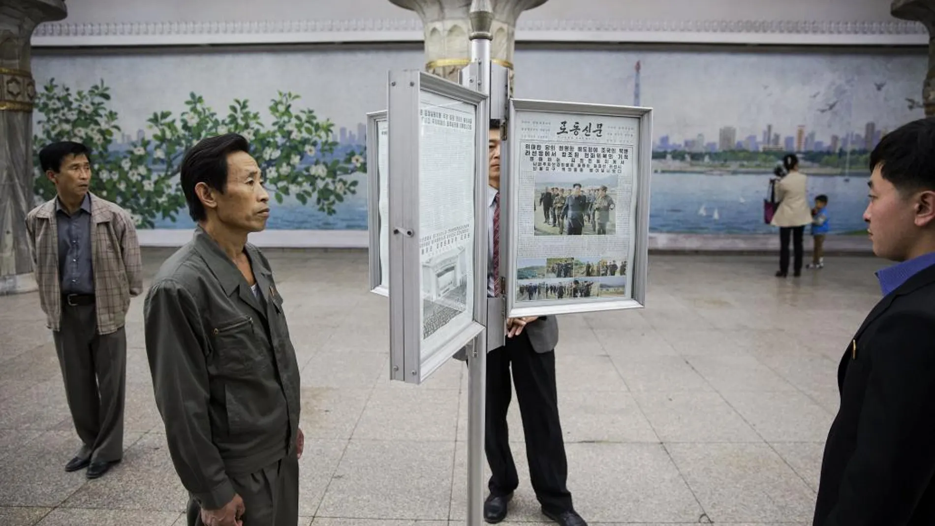 Norcoreanos leen periódicos en el metro durante una visita organizada de periodistas extranjeros a Pyongyang para la celebración del 70 aniversario del Partido de los Trabajadores