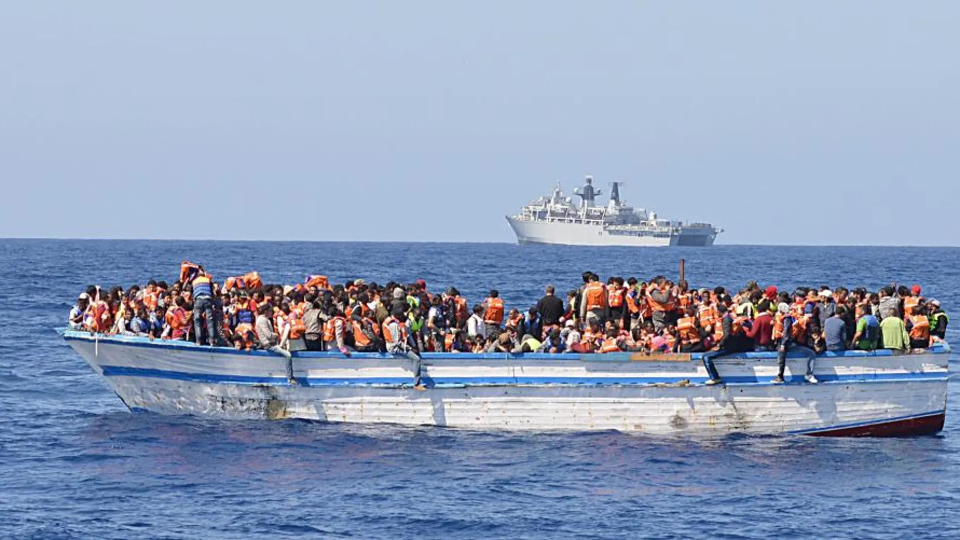 Inmigrantes viajando en un bote de madera viajando en aguas al norte de Libia