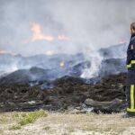 Un bombero observa los neumáticos que arden en el incendio de Seseña (Toledo), y cuyas labores de extinción continúan.