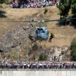 Dos soldados descienden de un helicóptero durante la exhibición que los tres ejércitos han realizado dentro de los actos programados con motivo del Día de las Fuerzas Armadas