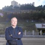 El director general de Protos, Carlos Villar, posa con las instalaciones de la bodega vieja al fondo, bajo las faldas del castillo de Peñafiel, sede del Museo Provincial del Vino de Valladolid, en lo alto, testigo de todo