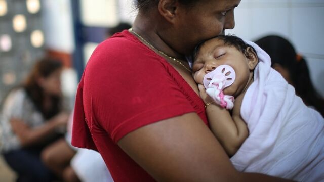 Una madre junto a un niño afectado por el virus.