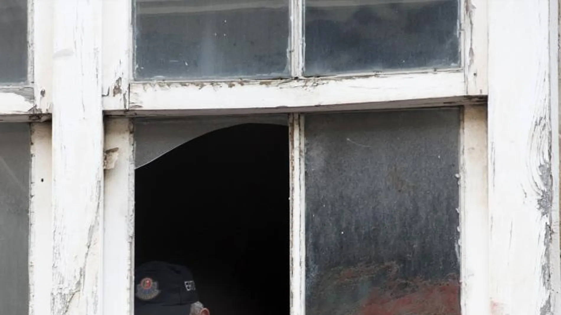 Un ertzaina toma pruebas en la ventana del domicilio del número 14 de la calle Libertad de Vitoria