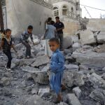 Unos niños juegan en las ruinas de una casa destruida en un ataque aéreo en Sanaa