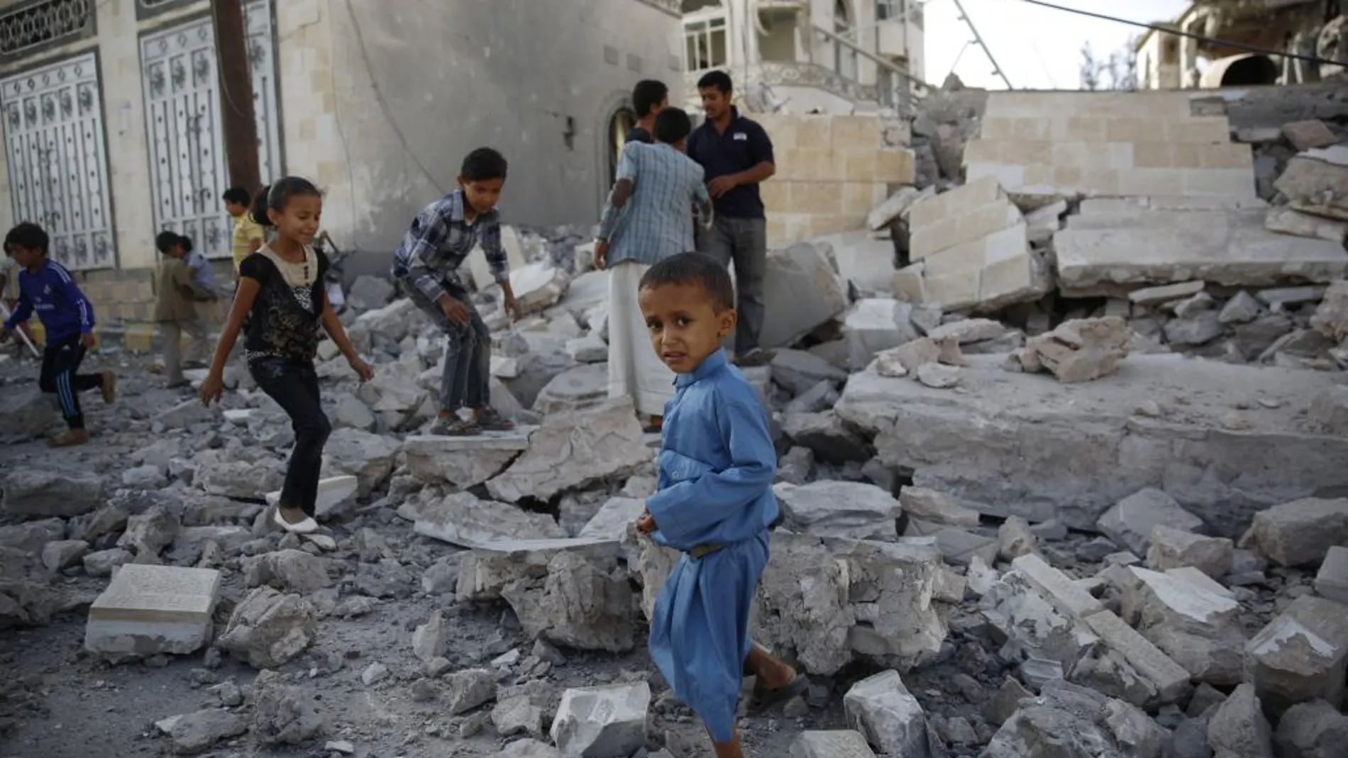 Unos niños juegan en las ruinas de una casa destruida en un ataque aéreo en Sanaa