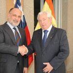 El presidente del Tribunal Constitucional Francisco Pérez de los Cobos, presenta el saludo protocolario al embajador chileno Francisco Marambio Vial, delante de las banderas de ambos países.