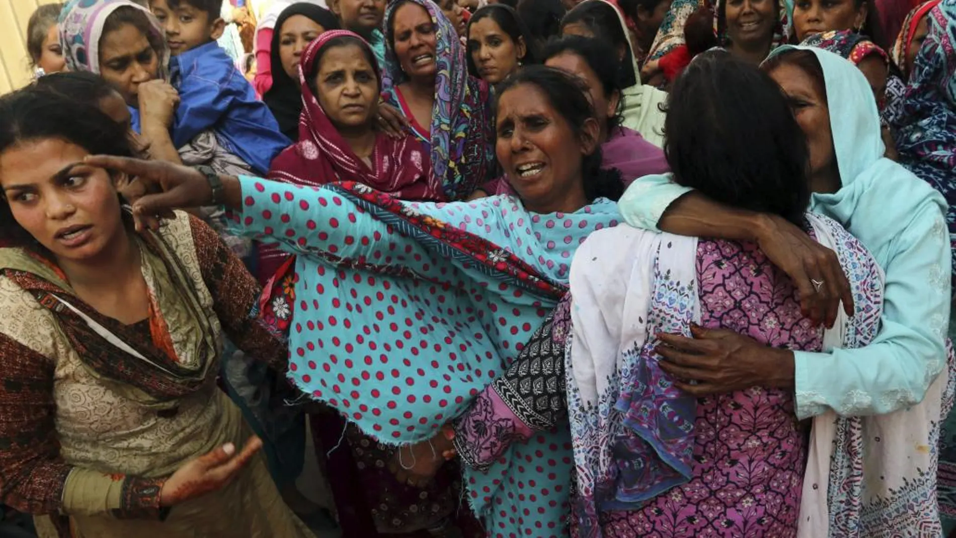 Varias personas lloran durante el funeral en honor a una víctima del ataque suicida del parque Gulshan Iqbal