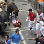 Los toros de El Tajo y de la Reina enfilan la calle de La Estafeta de Pamplona, creando varias situaciones de peligro a los corredores