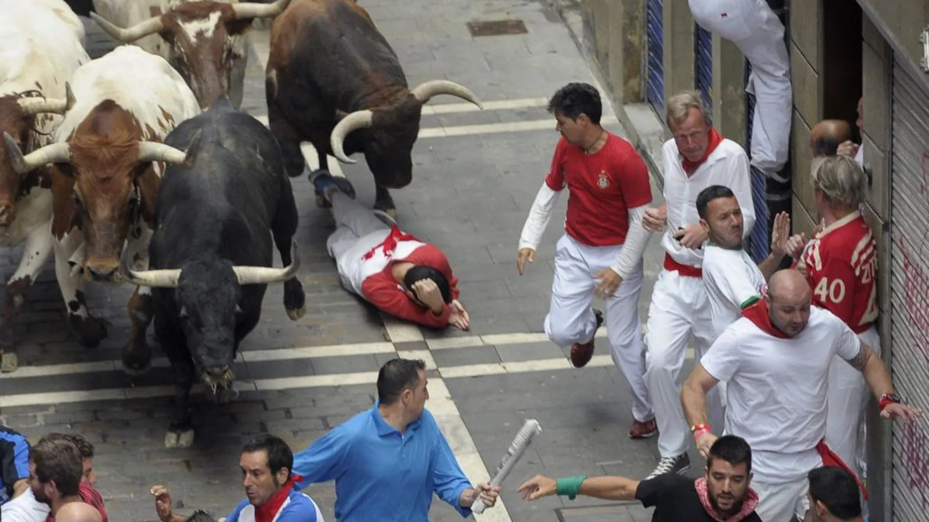 Los toros de El Tajo y de la Reina enfilan la calle de La Estafeta de Pamplona, creando varias situaciones de peligro a los corredores