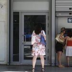 Atenienses hacen cola para retirar dinero de un cajero automático en una sucursal del Banco Nacional de Grecia