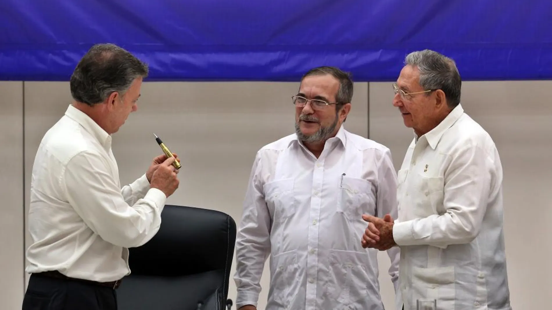 El líder de las FARC, Rodrigo Londoño Echeverri, alias "Timochenko"(c), habla con los presidentes de Cuba, Raúl Castro (d), y de Colombia, Juan Manuel Santos (i), en La Habana (Cuba)