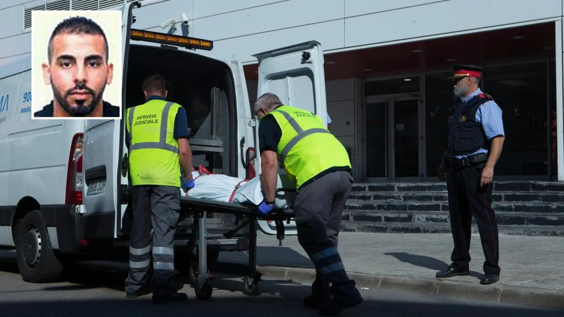 Miembros del servicio judicial retiran el cadáver del hombre que ha sido abatido esta mañana al intentar acceder a la comisaría de los Mossos de Cornellà con un cuchillo en la mano/Efe