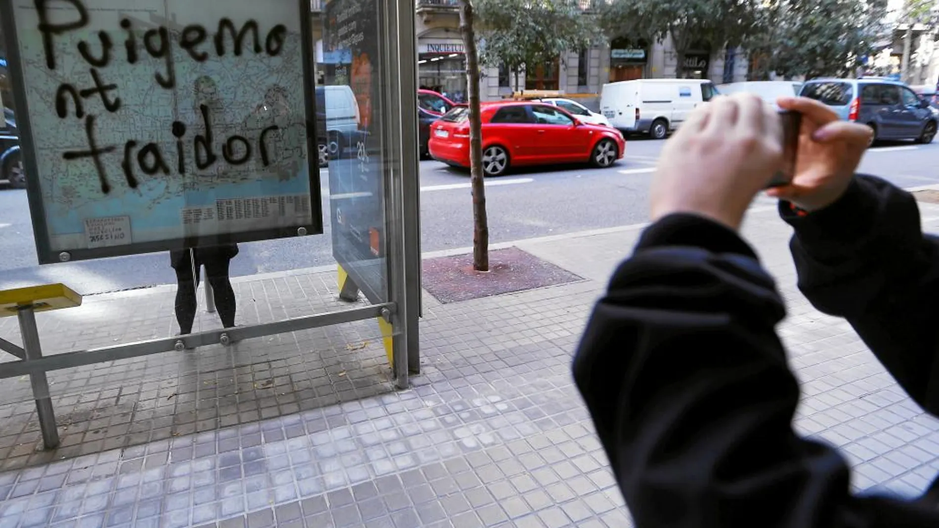 Cartel en una parada de autobús de Barcelona con un mensaje alusivo al presidente de la Generalitat, Carles Puigdemont