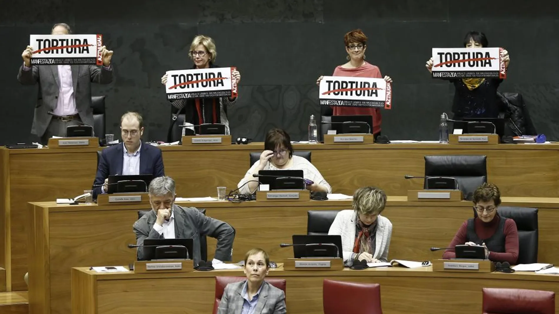 Los parlamentarios de EH Bildu en la Cámara foral han exhibido carteles con la palabra "Tortura"durante la intervención hoy en el pleno de la portavoz del PPN, Ana Beltrán