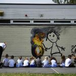 Los alumnos del colegio de primaria observan el mural del artista callejero