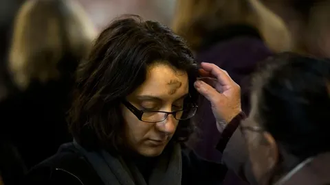 Una mujer recibe la bendición del Miércoles de Ceniza