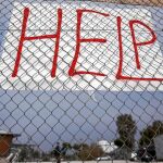 Un cartel solicitando ayuda para los inmigrantes cuelga del estadio Faliro, al sur de Atenas
