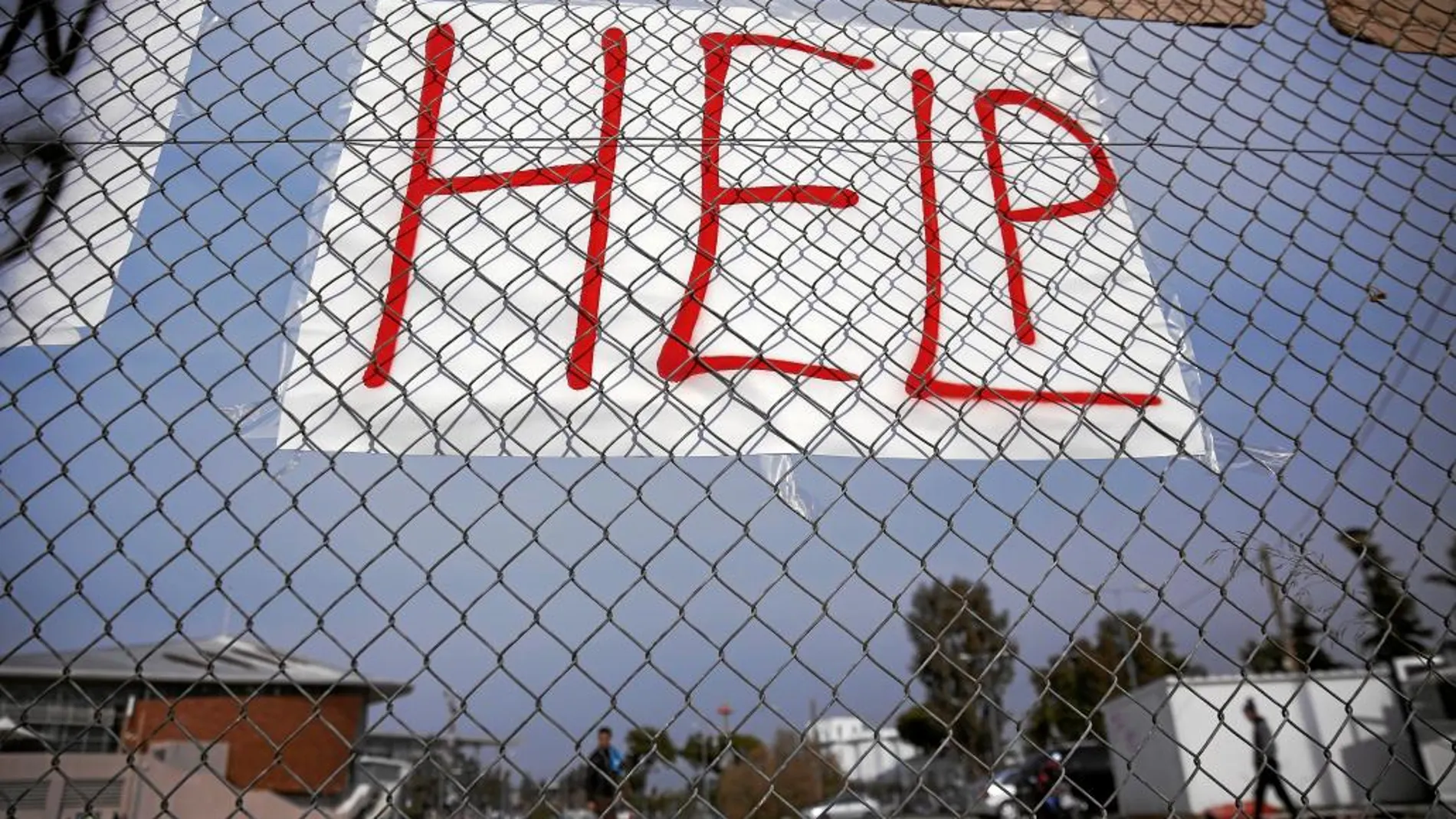 Un cartel solicitando ayuda para los inmigrantes cuelga del estadio Faliro, al sur de Atenas