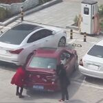 Momento en el que las dos mujeres tratan de levantar el coche para enderezarlo