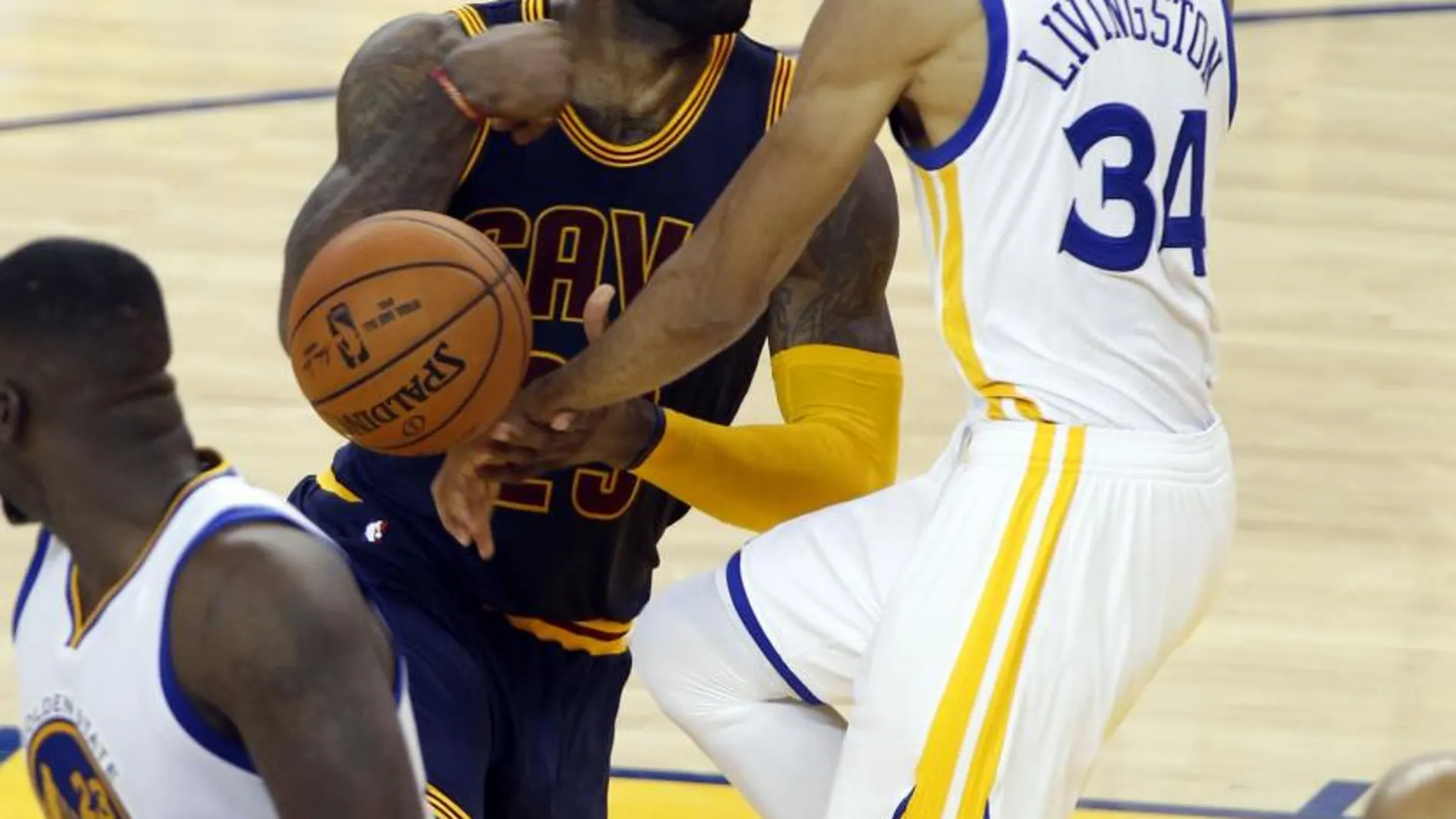 LeBron James (c) de Cleveland Cavaliers pierde el balón frente a Shaun Livingston (d) de Golden State Warriors