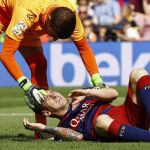 Leo Messi es atendido por el portero de Las Palmas, Javier Varas, tras lesionarse