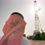 Un oficial de la compañía petrolera estatal observa un pozo de extracción de crudo en Arabia Saudí