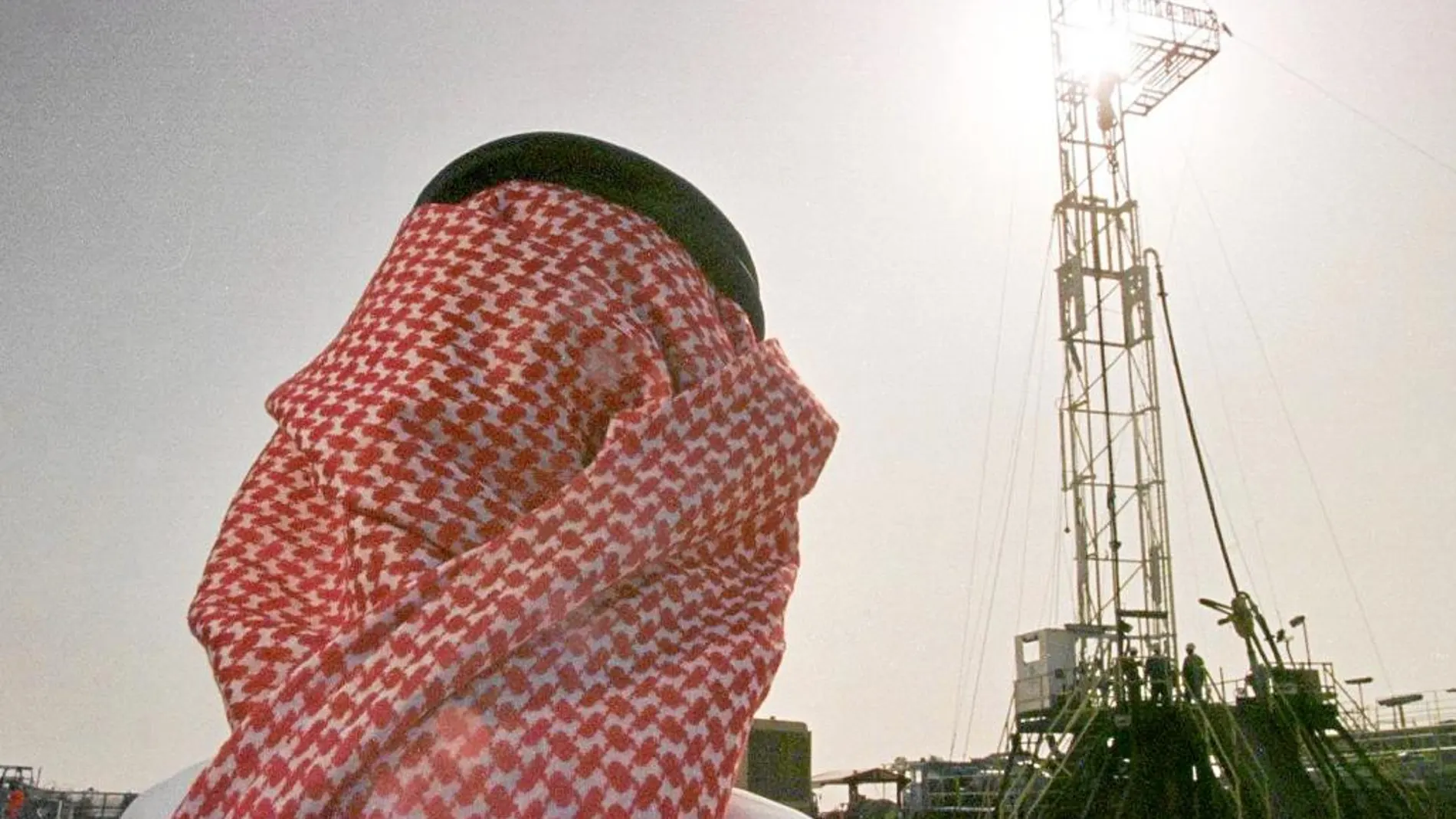Un oficial de la compañía petrolera estatal observa un pozo de extracción de crudo en Arabia Saudí