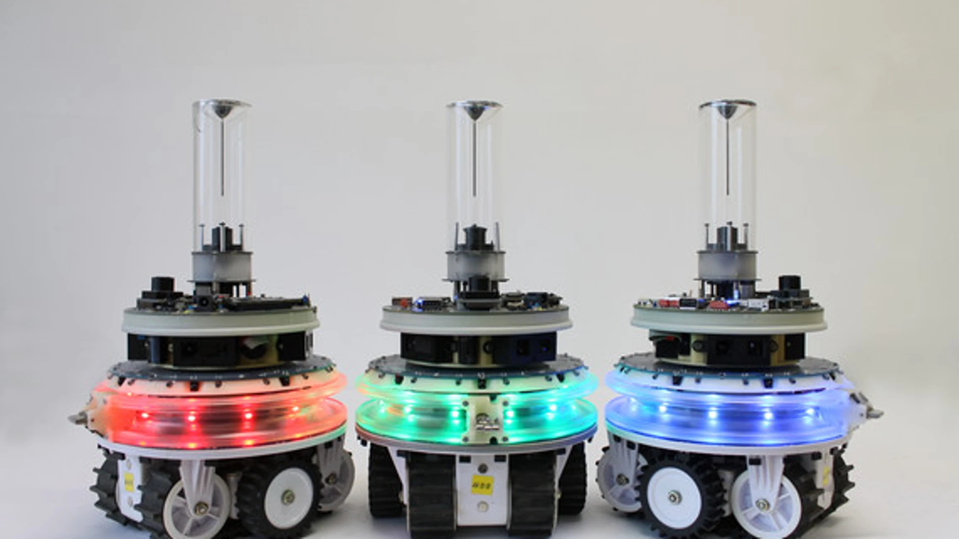 Tres robots autónomos con iluminación LED en diferentes colores