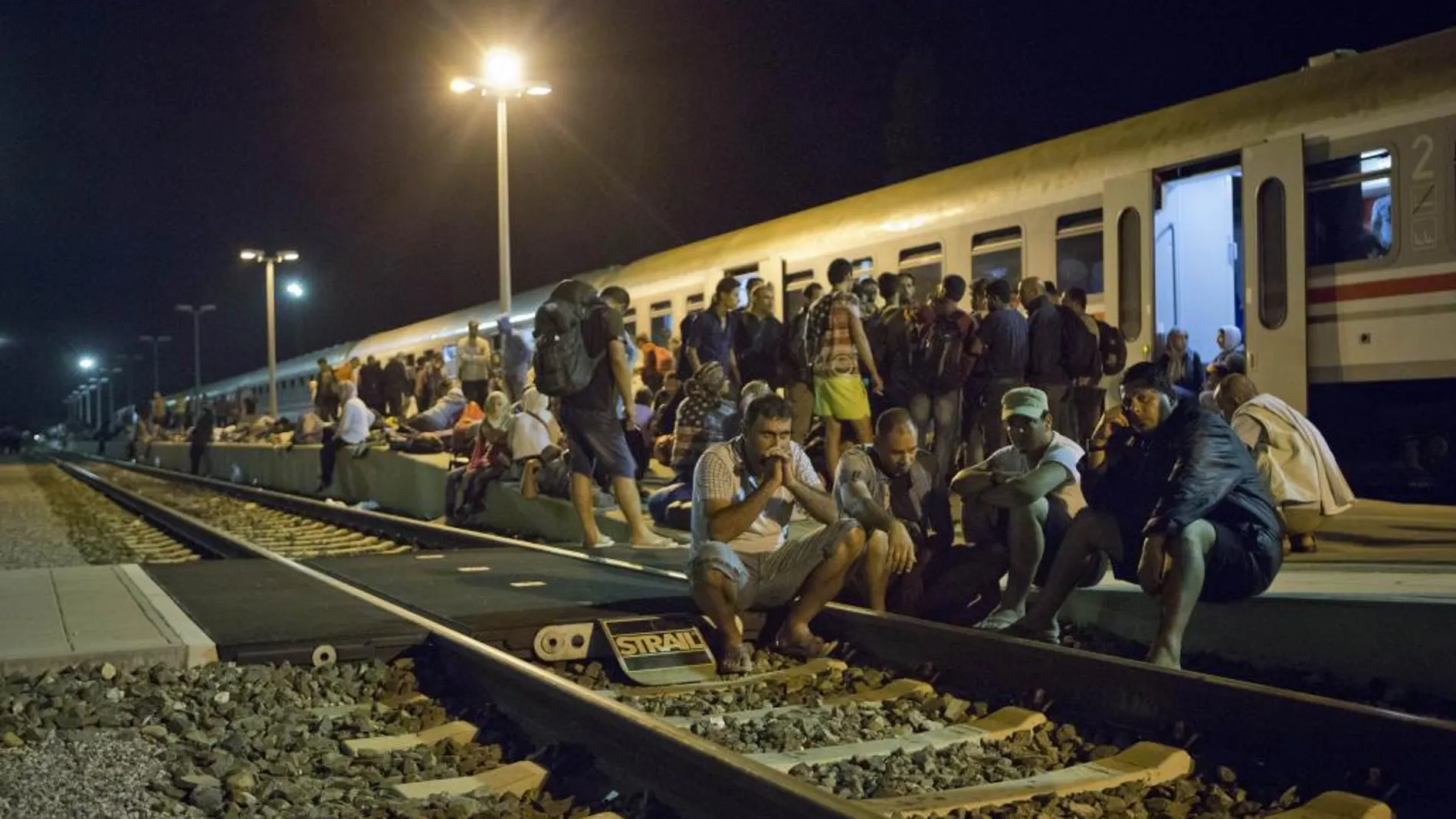 Decenas de inmigrantes esperan en las vías de tren junto a la frontera croata.