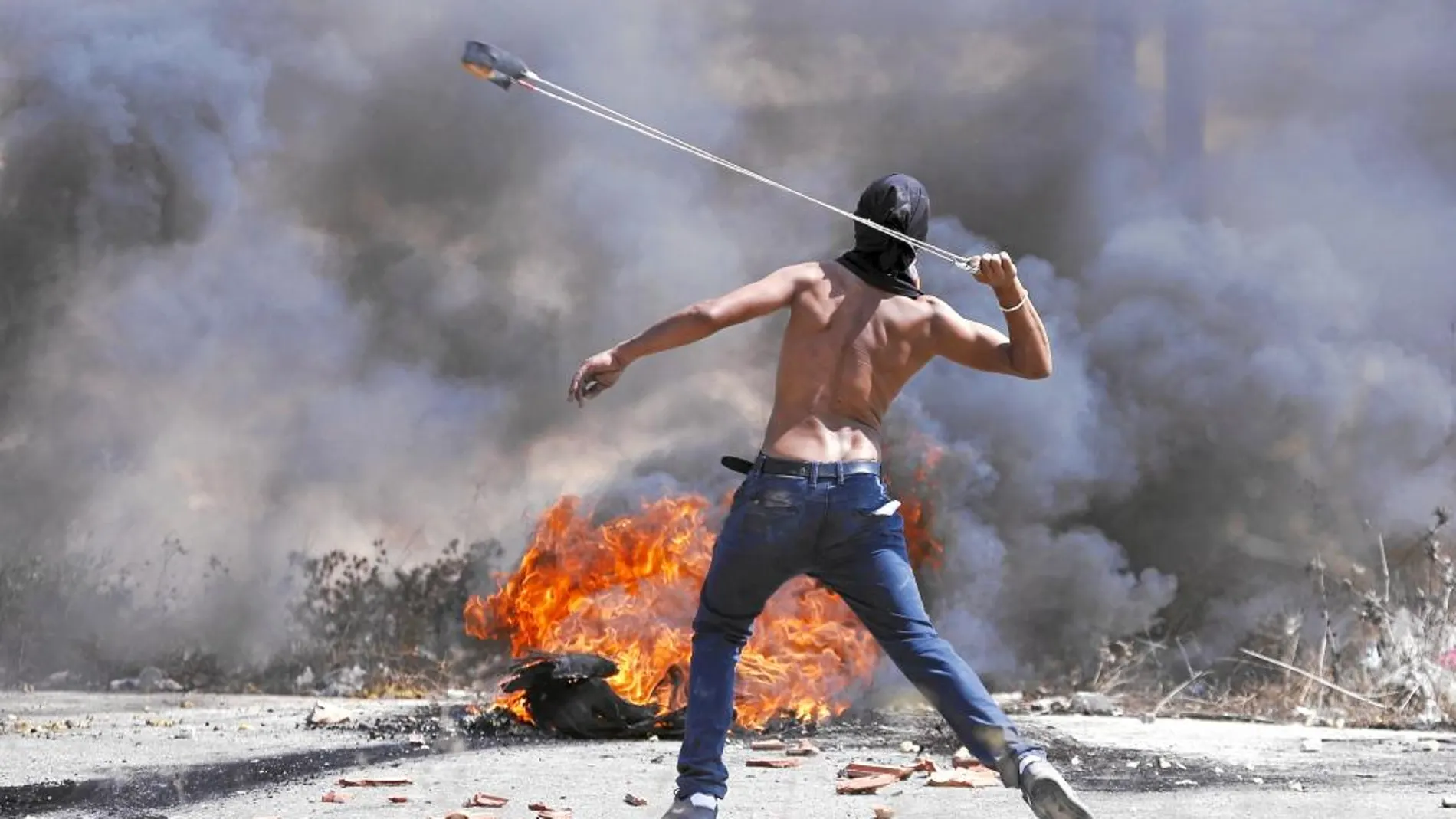 Un palestino se enfrenta a soldados israelíes en la colonia judía de Bet EI