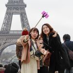 Dos turistas se hacen un selfie frente a la torre Eiffel