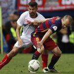El centrocampista del FC Barcelona Andrés Iniesta (d) lucha el balón con el argentino Éver Banega, del Sevilla FC