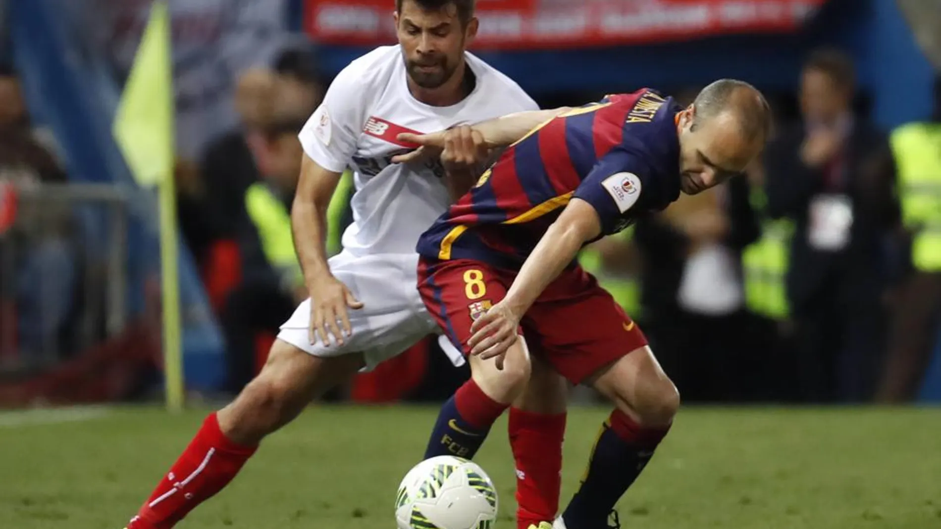 El centrocampista del FC Barcelona Andrés Iniesta (d) lucha el balón con el argentino Éver Banega, del Sevilla FC