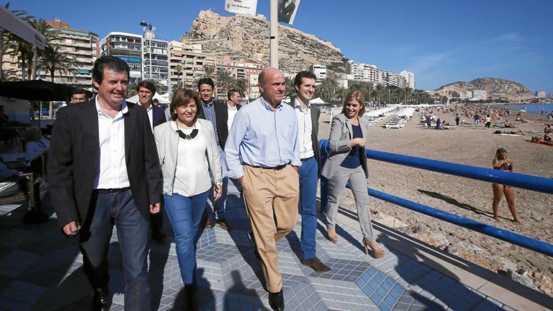 El ministro de Economía, Luis De Guindos (c), y el vicesecretario de Comunicación del PP, Pablo Casado (2ºd), junto a Bonig (2ªi), y el presidente provincial de Alicante, José Ciscar (i), dan un paseo antes de la ponencia