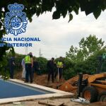 Imagen de varios agentes analizando el jardín en el que fueron encontrados los restos