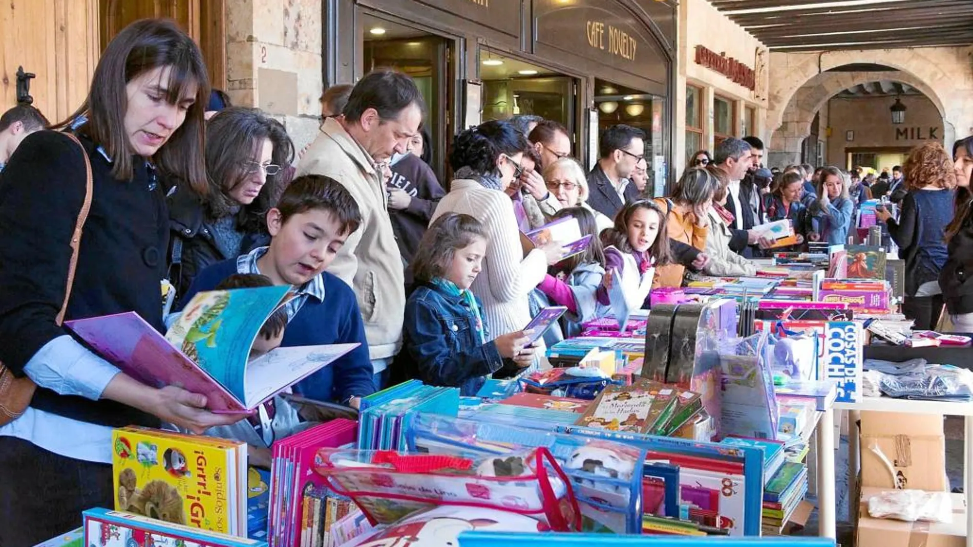 Numeroso público visitan a algunas de las librerías instaladas en los soportales de la Plaza Mayor