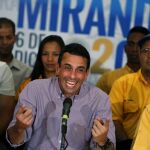 El líder opositor venezolano, excandidato presidencial y gobernador del estado Miranda, Henrique Capriles (d), sonríe al ofrecer una conferencia de prensa, acompañado de varios de los 99 diputados electos