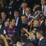 Busquets (i) y Andrés Iniesta levantan el trofeo