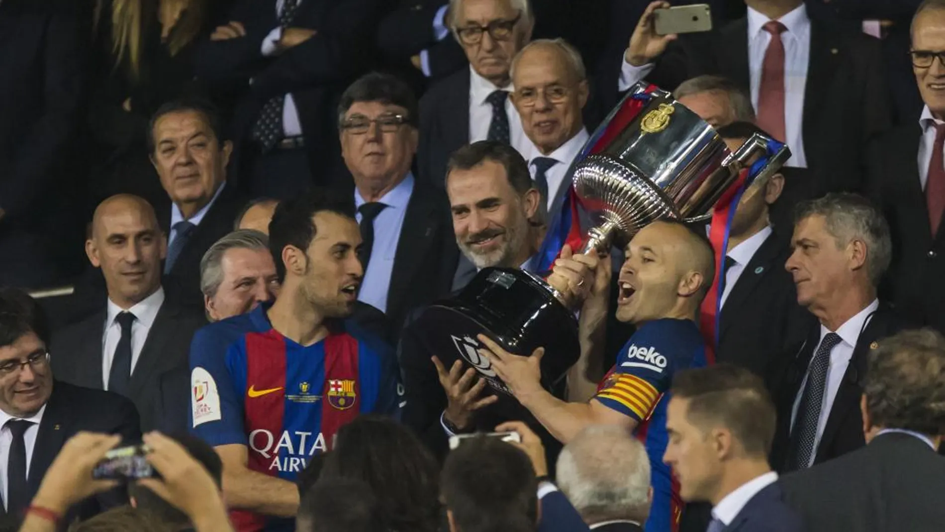 Busquets (i) y Andrés Iniesta levantan el trofeo