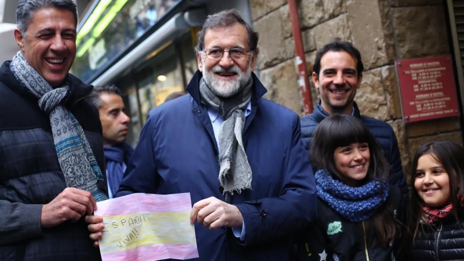 Mariano Rajoy y García Albiol posan con una bandera de España pintada por una niña
