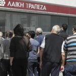 Varias personas hacen cola a las puertas de una sucursal de Laiki Bank en Limassol (Chipre) hoy, jueves 28 de marzo de 2013.