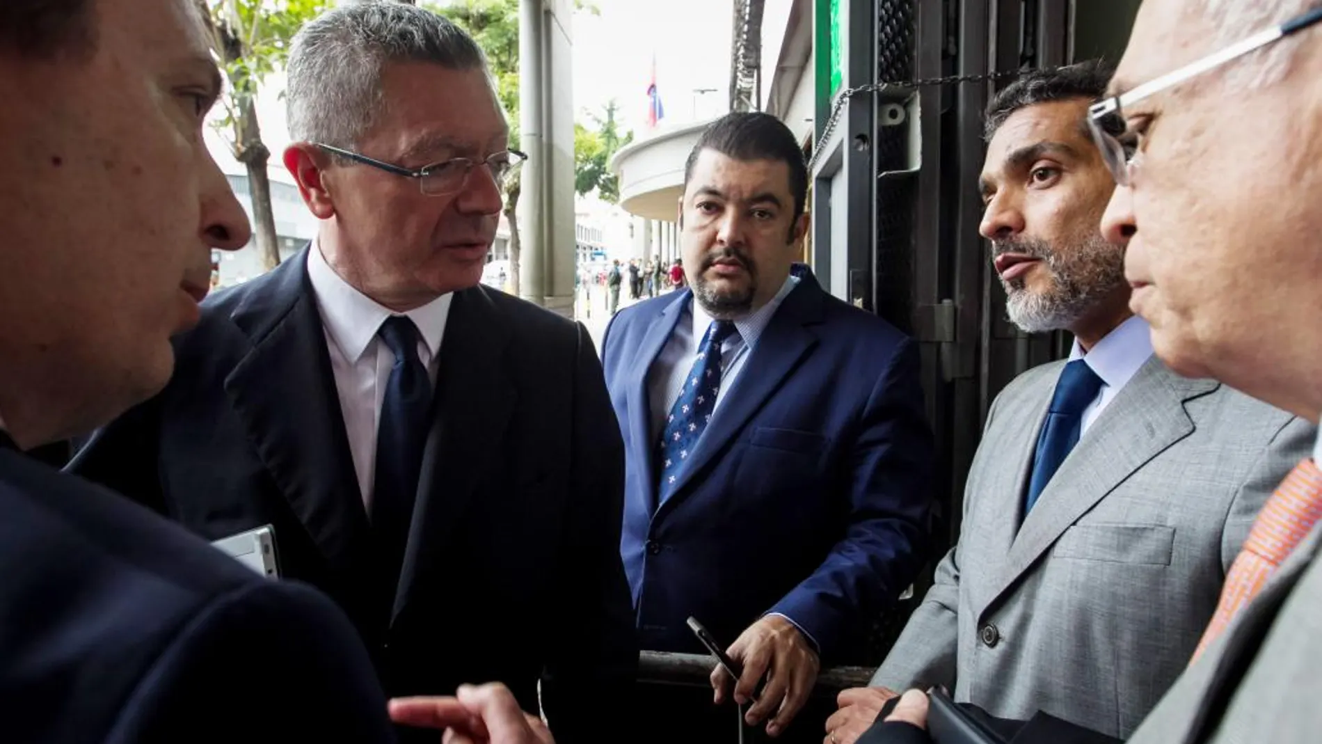 Javier Cremades y Alberto Ruiz Gallardón hablan con el abogado defensor del opositor venezolano Leopoldo López, Juan Carlos Gutiérrez en Caracas