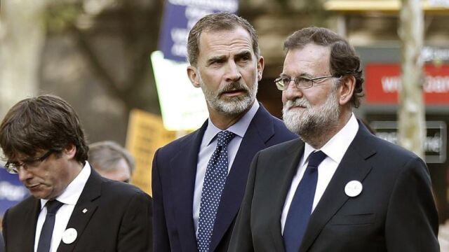 Felipe VI junto al presidente del Gobierno, Mariano Rajoy (d), y el president de la Generalitat, Carles Puigdemont (i), durante la manifestación contra los atentados yihadistas en Cataluña