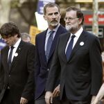 Felipe VI junto al presidente del Gobierno, Mariano Rajoy (d), y el president de la Generalitat, Carles Puigdemont (i), durante la manifestación contra los atentados yihadistas en Cataluña