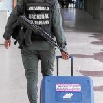 Un miembro de la Guardia Nacional armado traslada una máquina electoral