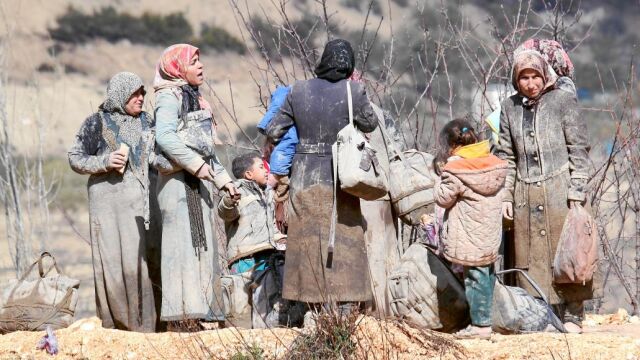Familias de refugiados buscan dónde acampar al aire libre a la espera de obtener el permiso para cruzar a Turquía desde Siria