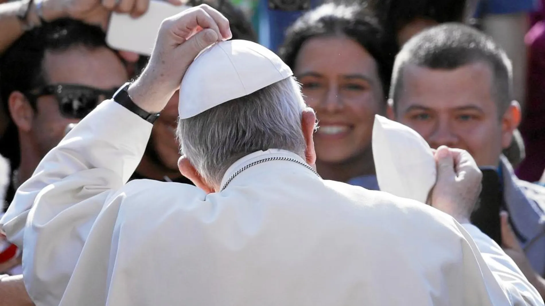 Intercambio de solideos. El Papa intercambia su solideo con uno de los miles fieles que asistieron ayer a San Pedro a escuchar su alocución del Miércoles Santo
